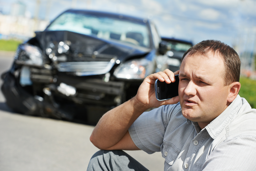 Man calling a car accident attorney for a consultation after an accident